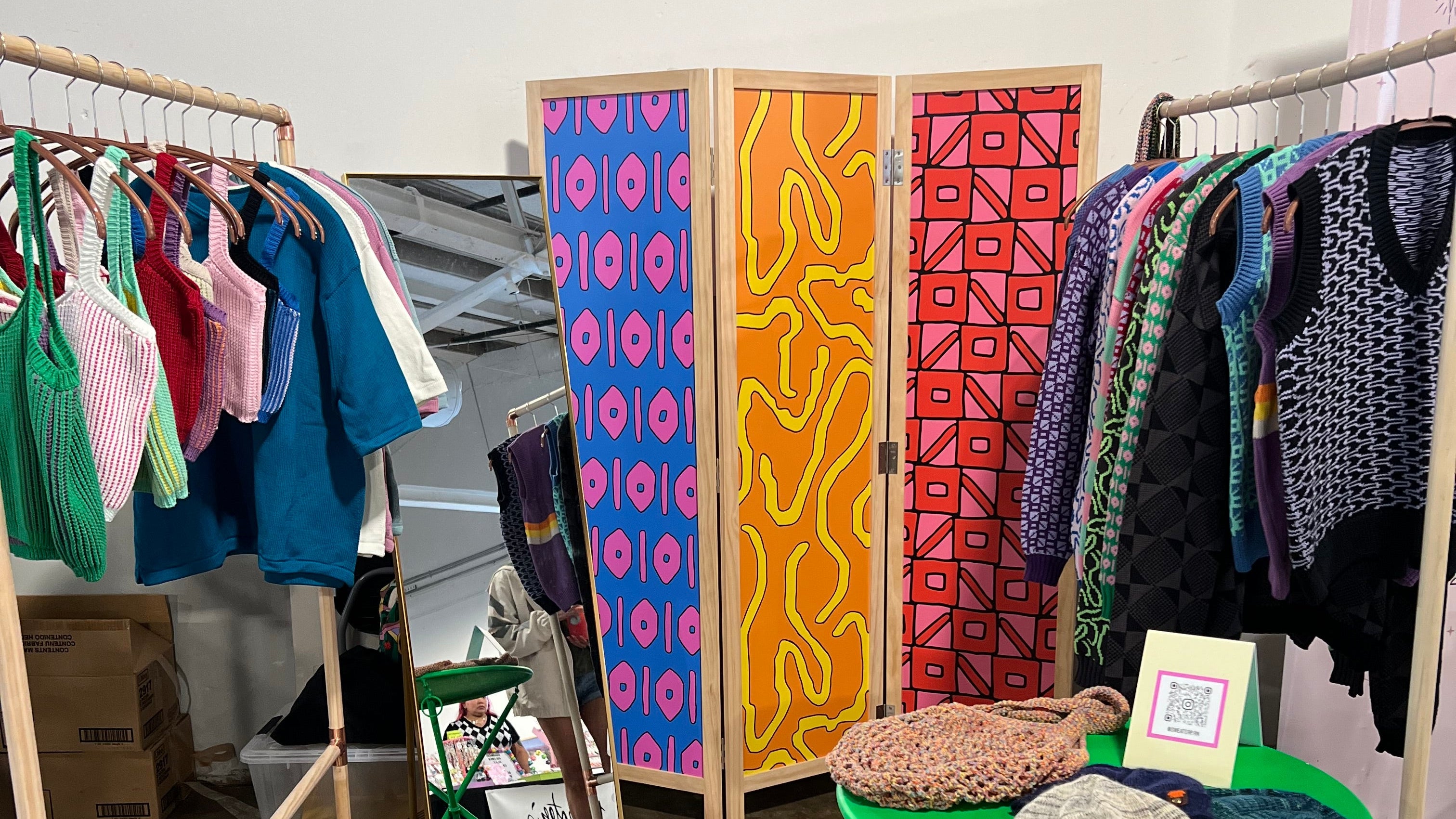 Colorful patterned boxes on a stand against a gray wall.